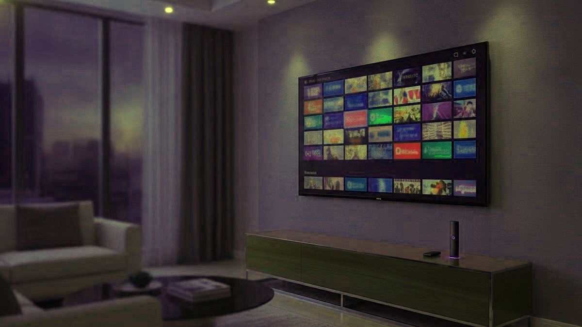 A living-room TV showing an IPTV channel guide with a streaming stick on the console
